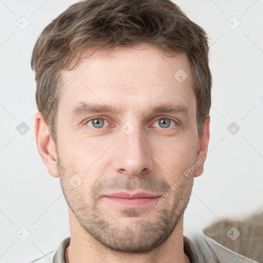 Joyful white young-adult male with short  brown hair and grey eyes