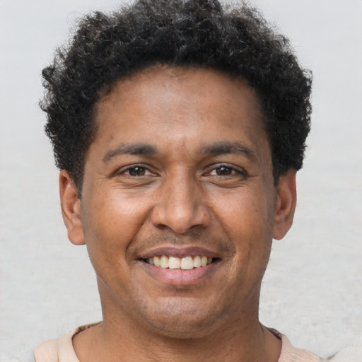 Joyful latino adult male with short  brown hair and brown eyes
