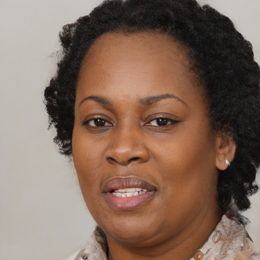Joyful black adult female with medium  brown hair and brown eyes