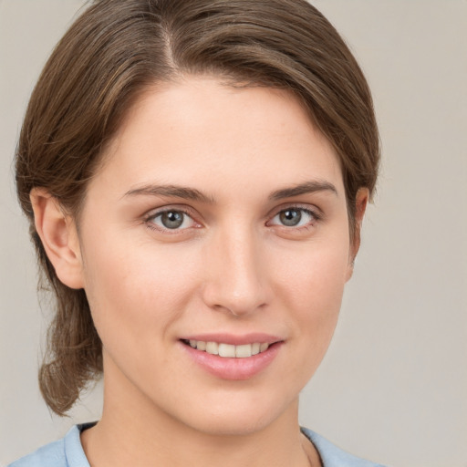 Joyful white young-adult female with medium  brown hair and grey eyes