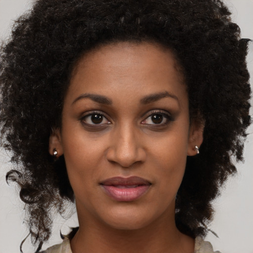 Joyful black young-adult female with long  brown hair and brown eyes