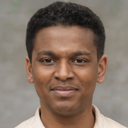 Joyful black young-adult male with short  brown hair and brown eyes