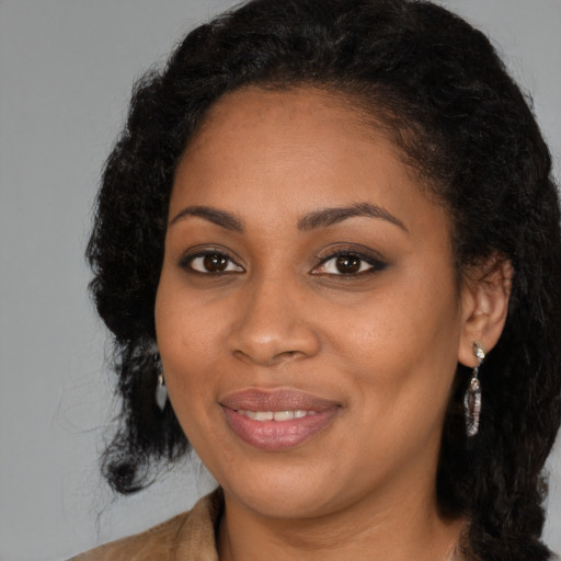 Joyful black young-adult female with long  black hair and brown eyes