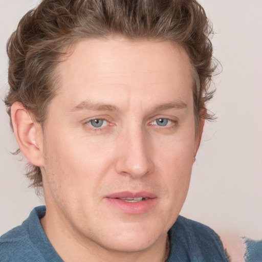 Joyful white young-adult male with short  brown hair and blue eyes