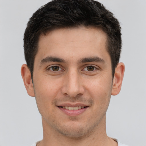 Joyful white young-adult male with short  brown hair and brown eyes