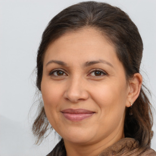 Joyful latino adult female with medium  brown hair and brown eyes