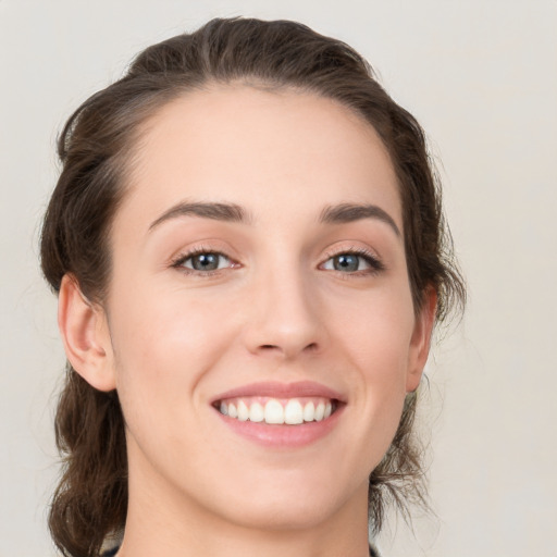 Joyful white young-adult female with medium  brown hair and green eyes