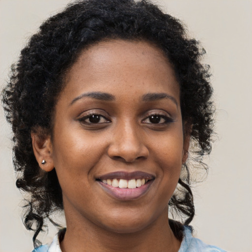 Joyful black young-adult female with medium  brown hair and brown eyes