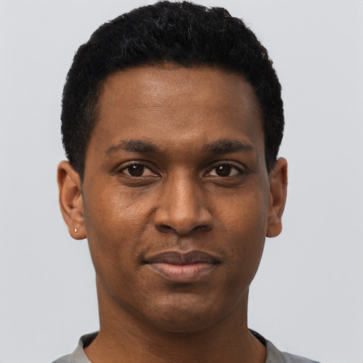 Joyful black young-adult male with short  black hair and brown eyes