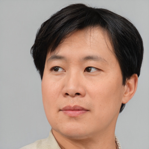 Joyful asian adult male with short  brown hair and brown eyes
