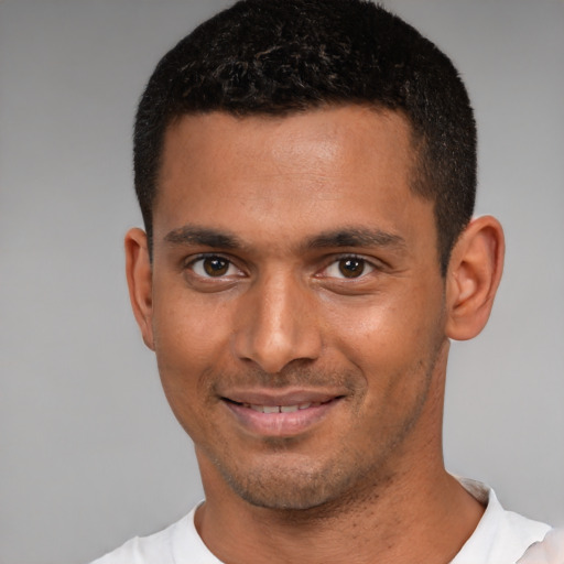 Joyful black young-adult male with short  black hair and brown eyes