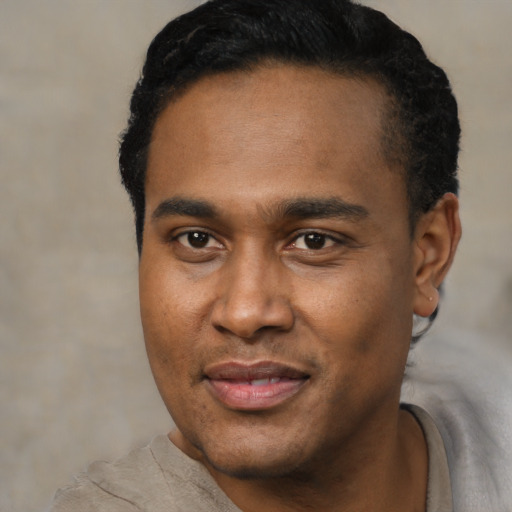 Joyful black young-adult male with short  black hair and brown eyes