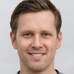 Joyful white adult male with short  brown hair and grey eyes