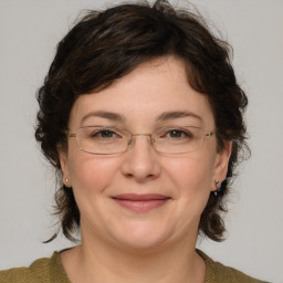 Joyful white adult female with medium  brown hair and green eyes