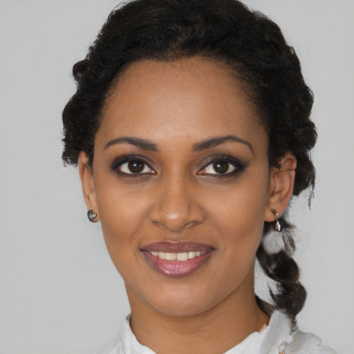Joyful black young-adult female with short  black hair and brown eyes