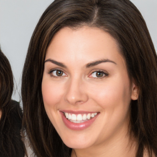 Joyful white young-adult female with long  brown hair and brown eyes