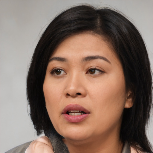 Joyful asian young-adult female with medium  black hair and brown eyes