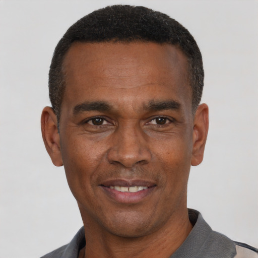 Joyful black adult male with short  black hair and brown eyes