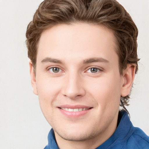 Joyful white young-adult male with short  brown hair and blue eyes