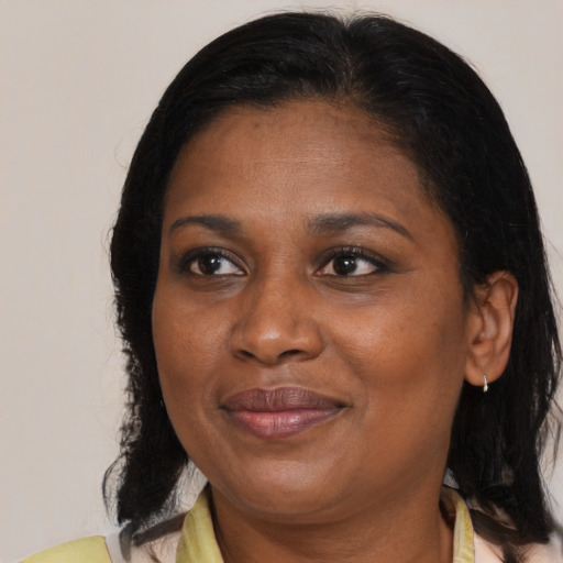Joyful black adult female with medium  brown hair and brown eyes