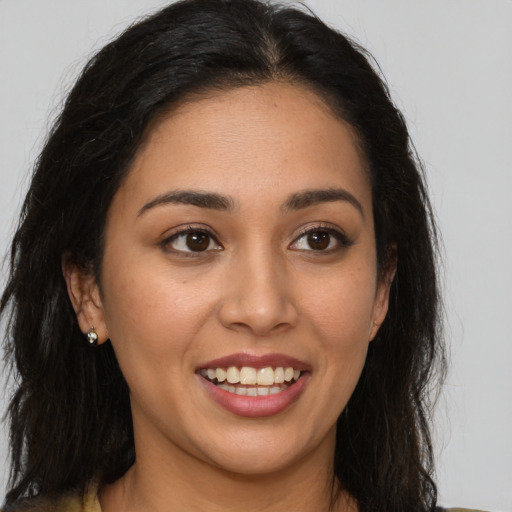 Joyful latino young-adult female with long  brown hair and brown eyes