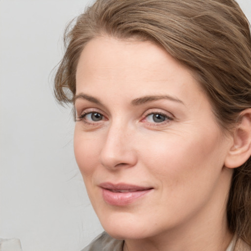 Joyful white young-adult female with medium  brown hair and blue eyes