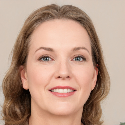 Joyful white adult female with medium  brown hair and green eyes