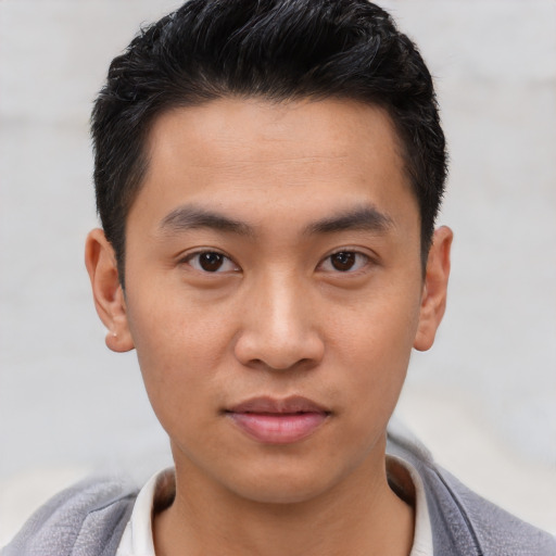 Joyful asian young-adult male with short  black hair and brown eyes
