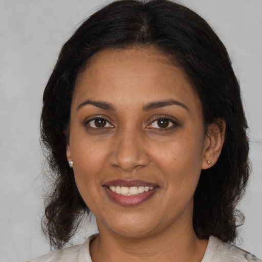 Joyful black adult female with medium  black hair and brown eyes