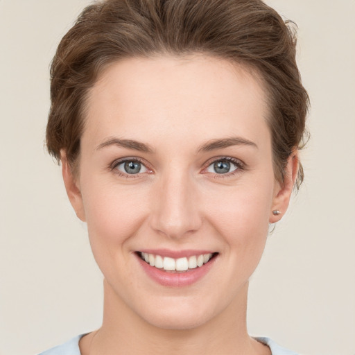 Joyful white young-adult female with short  brown hair and grey eyes