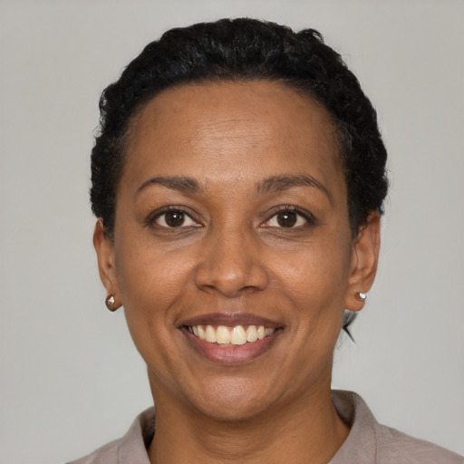 Joyful black adult female with short  black hair and brown eyes
