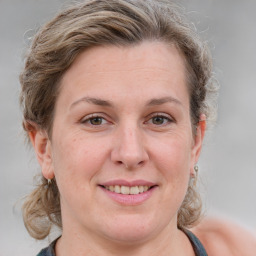 Joyful white adult female with medium  brown hair and grey eyes