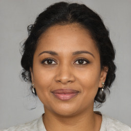 Joyful black adult female with medium  brown hair and brown eyes