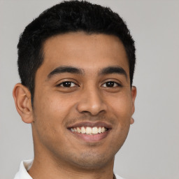 Joyful latino young-adult male with short  black hair and brown eyes