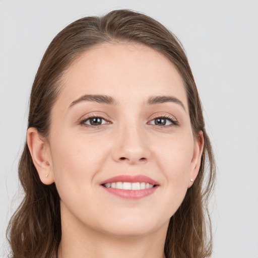 Joyful white young-adult female with long  brown hair and grey eyes