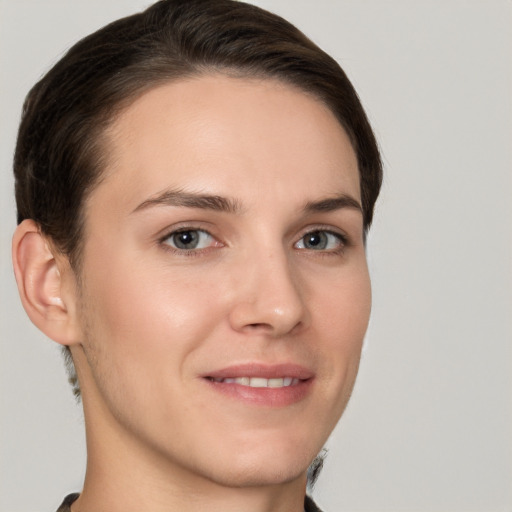 Joyful white young-adult female with short  brown hair and grey eyes