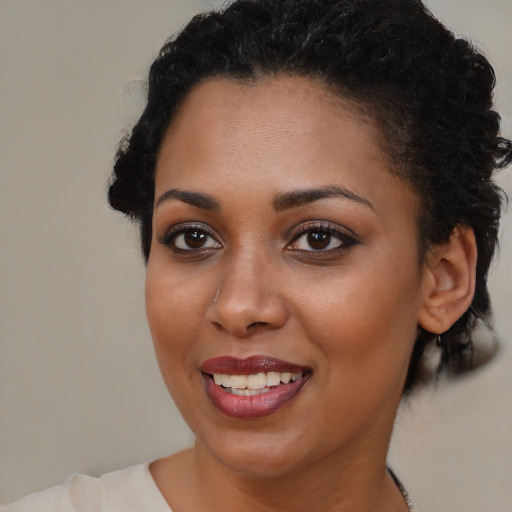 Joyful black young-adult female with short  brown hair and brown eyes