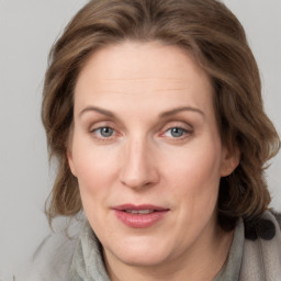 Joyful white adult female with medium  brown hair and grey eyes