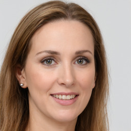 Joyful white young-adult female with long  brown hair and grey eyes