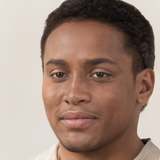 Joyful black young-adult male with short  brown hair and brown eyes