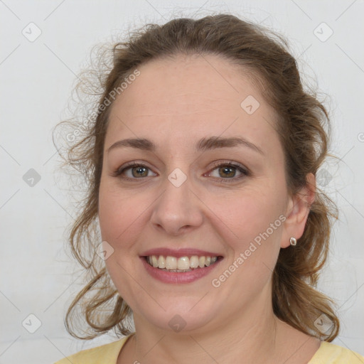 Joyful white young-adult female with medium  brown hair and grey eyes