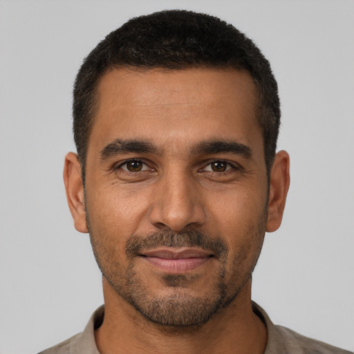 Joyful latino young-adult male with short  brown hair and brown eyes