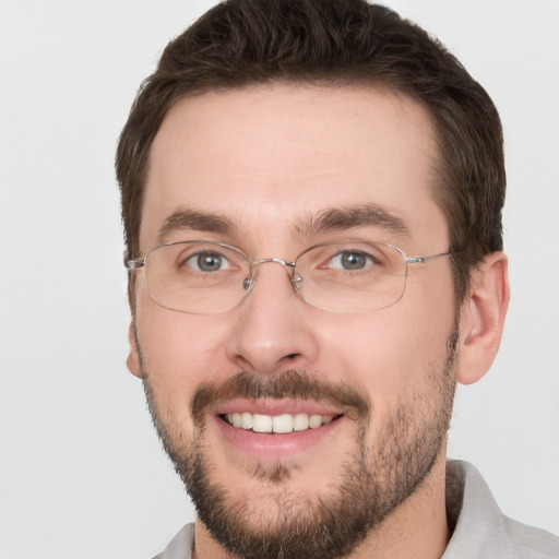 Joyful white young-adult male with short  brown hair and green eyes