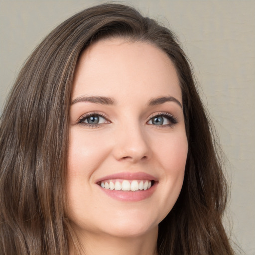 Joyful white young-adult female with long  brown hair and green eyes