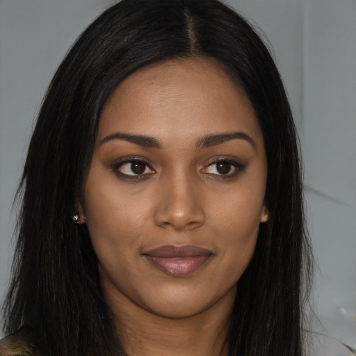 Joyful black young-adult female with long  brown hair and brown eyes