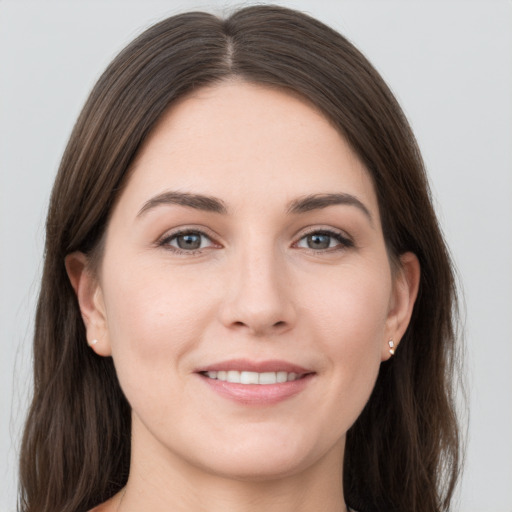 Joyful white young-adult female with long  brown hair and grey eyes