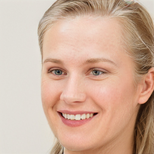 Joyful white young-adult female with long  brown hair and blue eyes