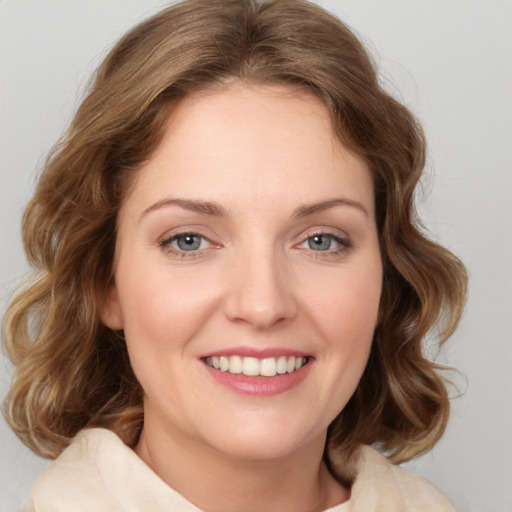 Joyful white young-adult female with medium  brown hair and green eyes