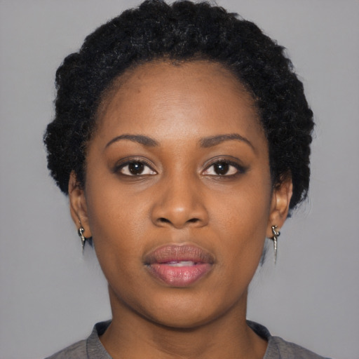 Joyful black young-adult female with short  black hair and brown eyes