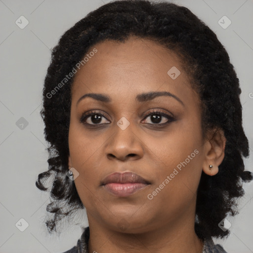 Joyful black young-adult female with long  black hair and brown eyes